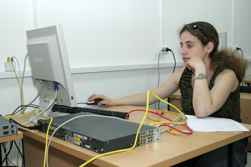 Ученик от Cisco Academy на ТУЕС работи на компютър с мрежово оборудване (рутери) в лабораторията
