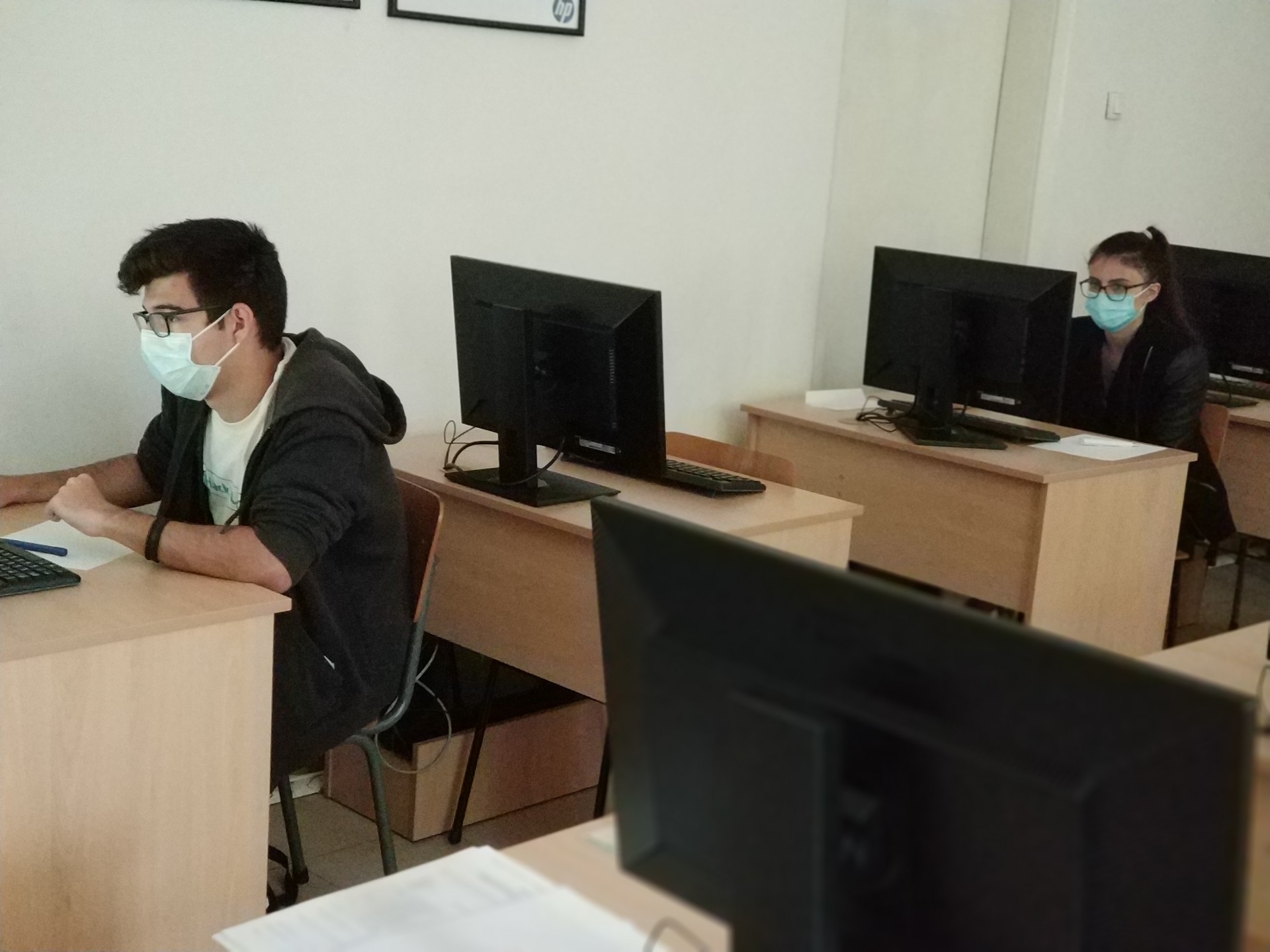 Двама ученици от ТУЕС пишат на хартия по време на теоретичния изпит на Националното състезание по компютърни мрежи 2021 г.